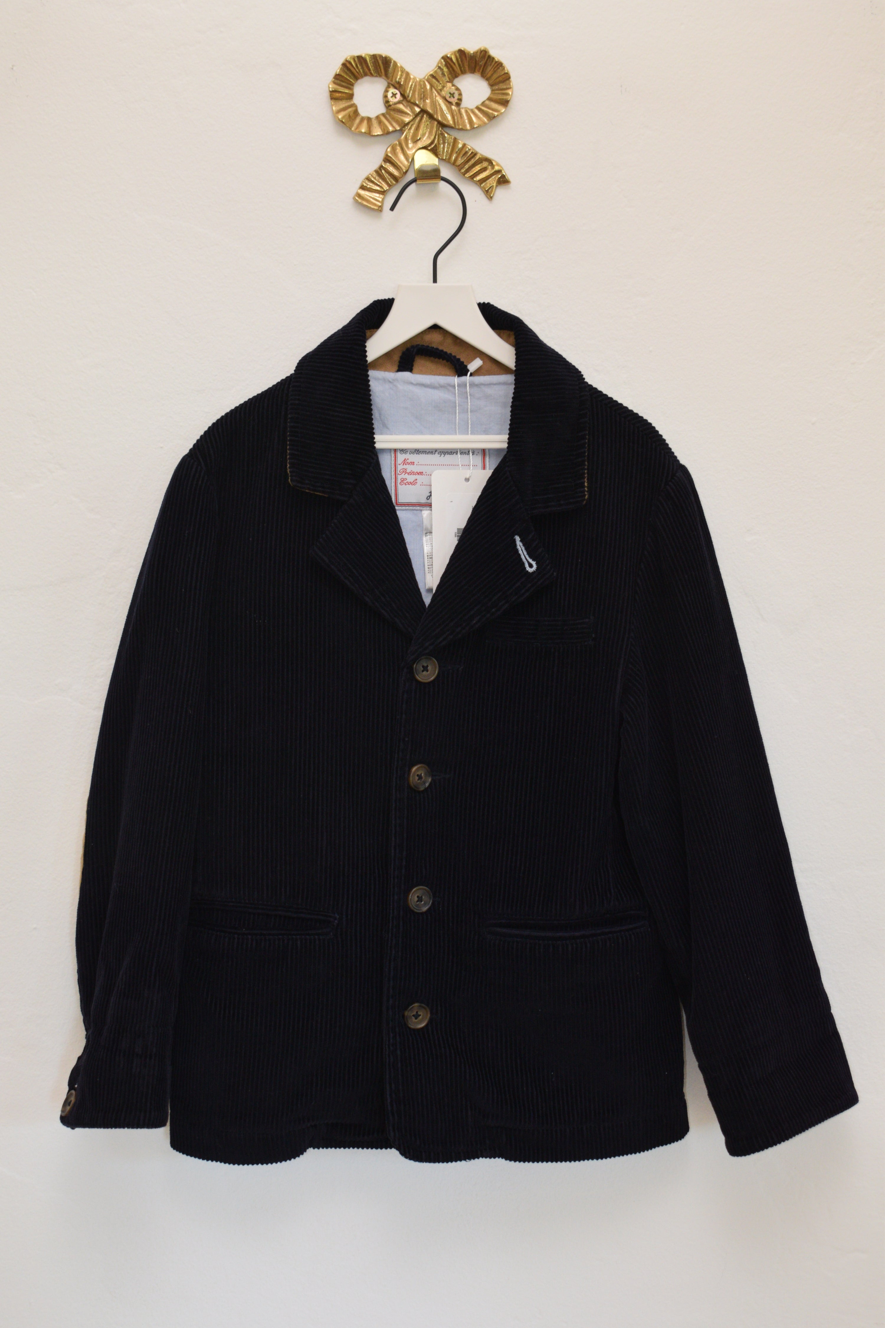 Jacadi navy corduroy blazer with tan elbow patches, size 8 years, on a white hanger against a neutral wall.