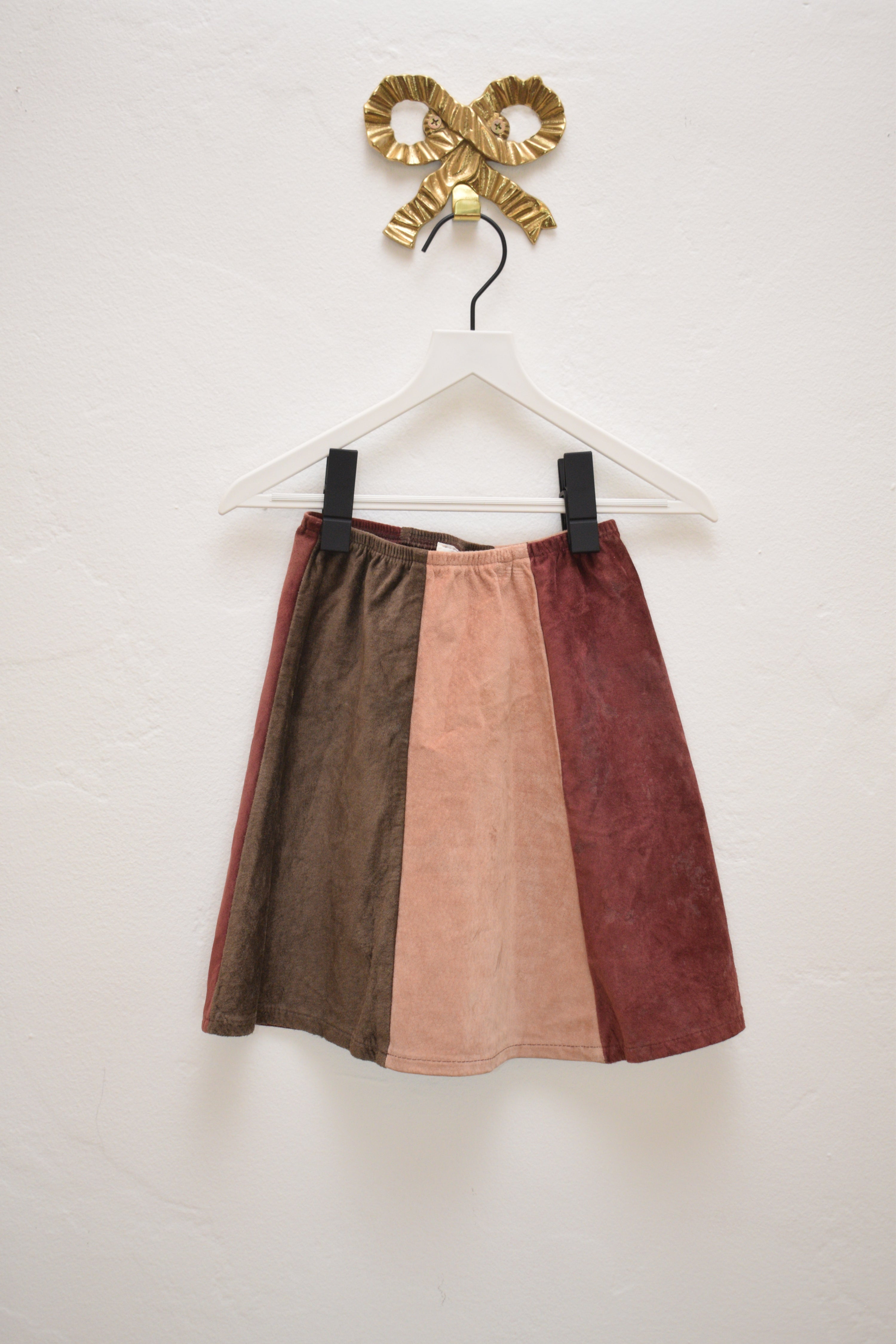 Vintage toddler patchwork suede skirt in rust, blush, olive, and burgundy with elastic waist, size 2, on white background.