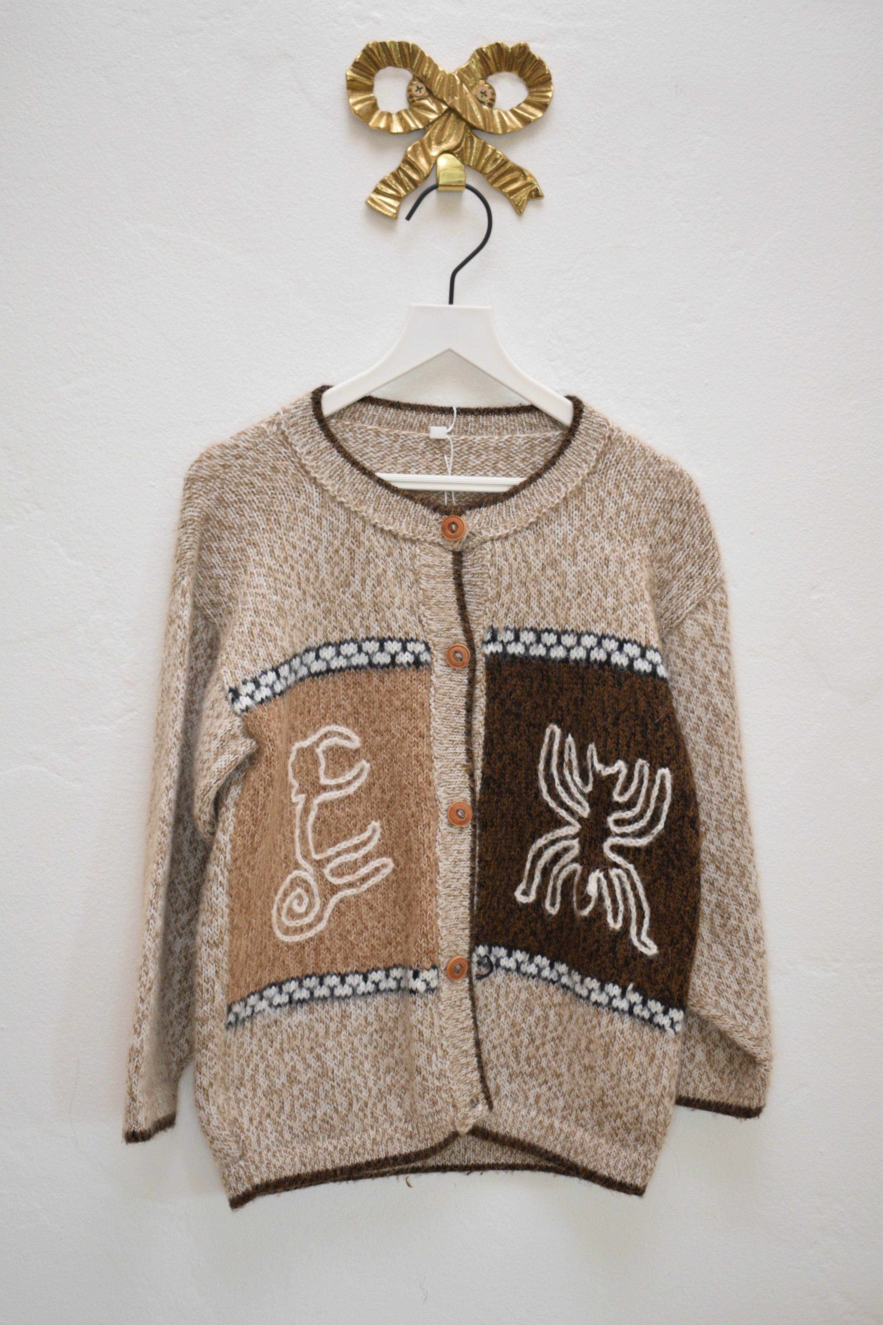Vintage Peruvian alpaca-blend kids cardigan with Nazca-inspired monkey and spider motif panels, tan marled knit, wood buttons, size 5–6