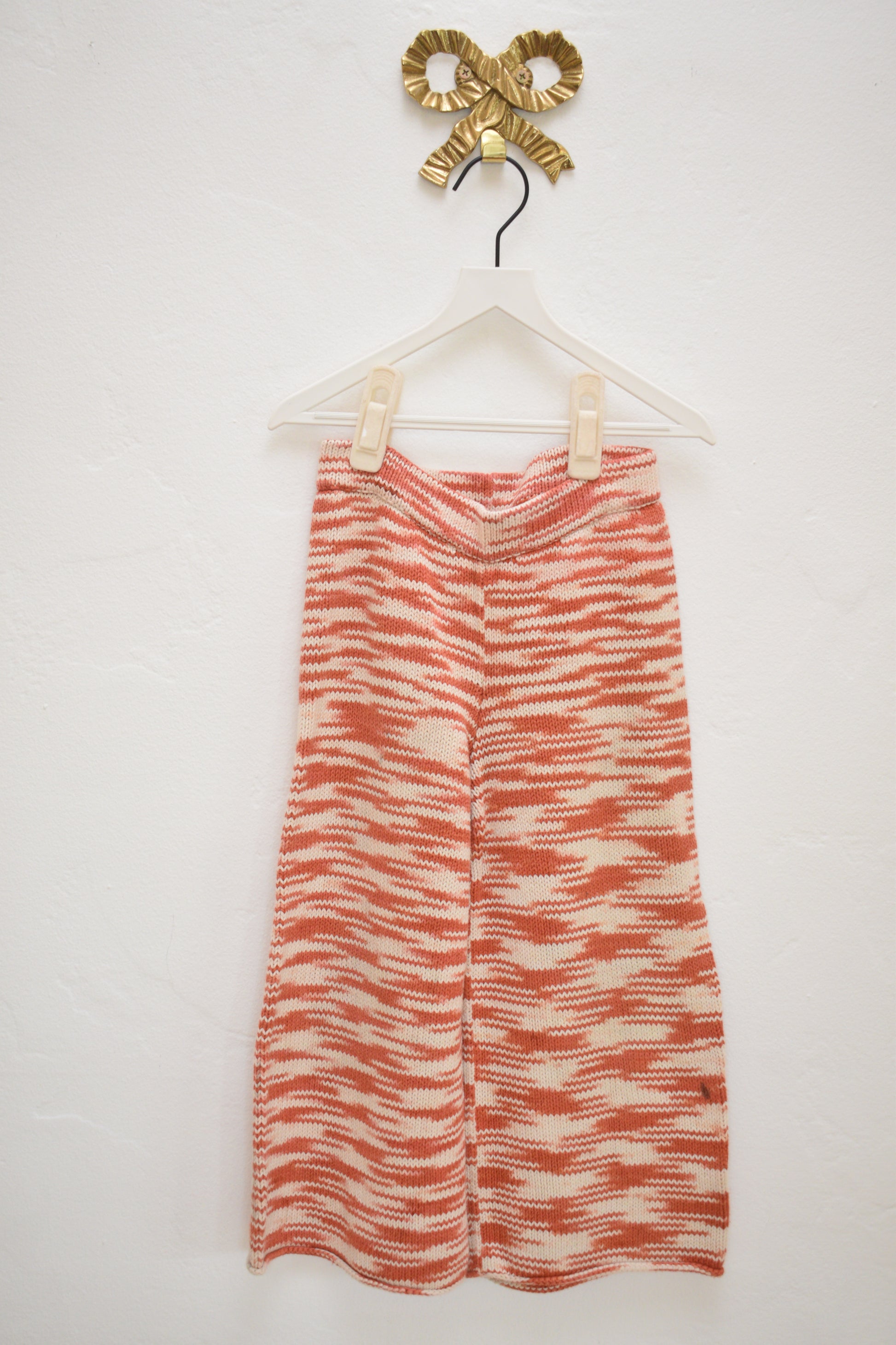 Misha & Puff red and cream marl knit kids pants, wide leg with elastic waist, size 4–5, on hanger against neutral wall.