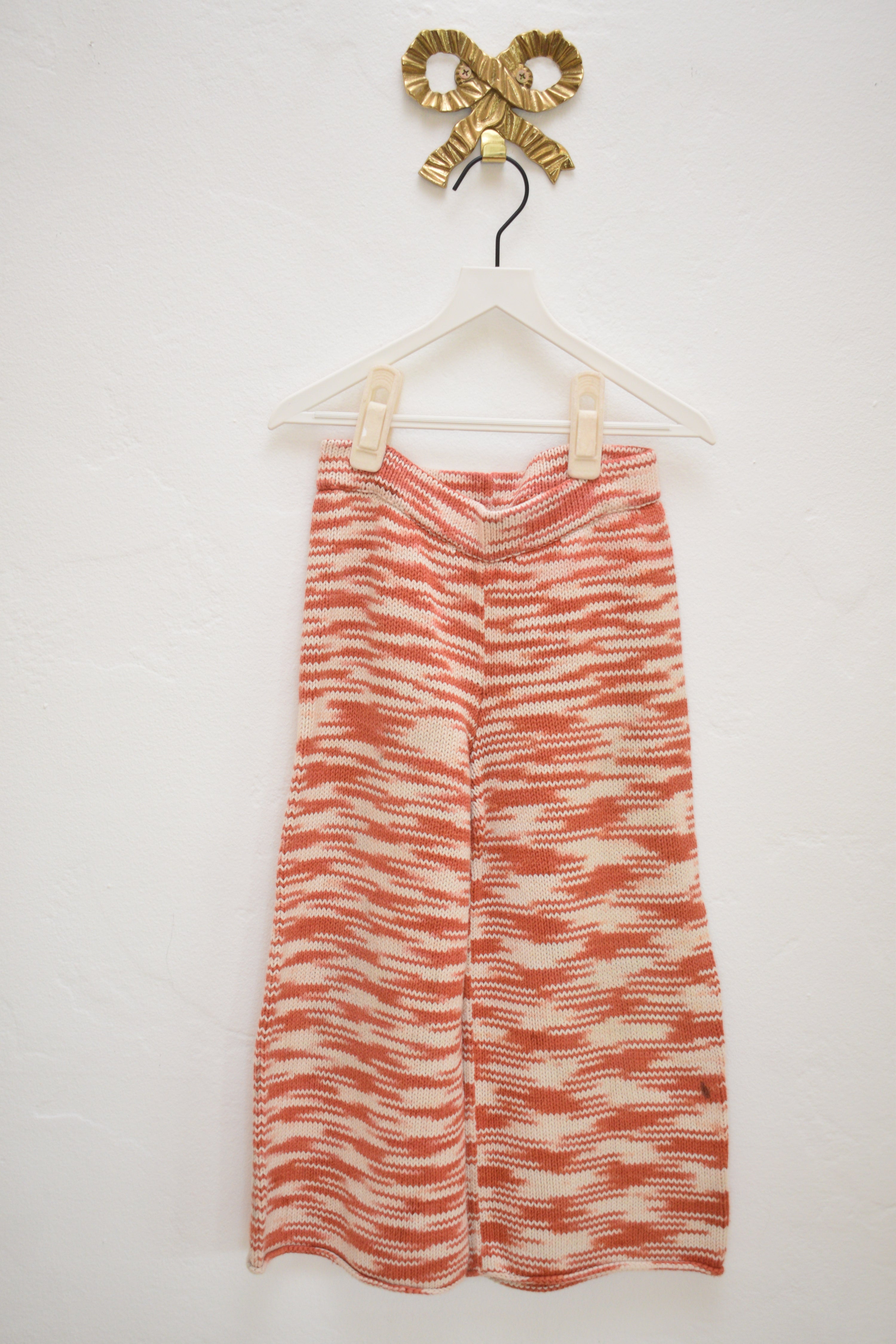 Misha & Puff red and cream marl knit kids pants, wide leg with elastic waist, size 4–5, on hanger against neutral wall.