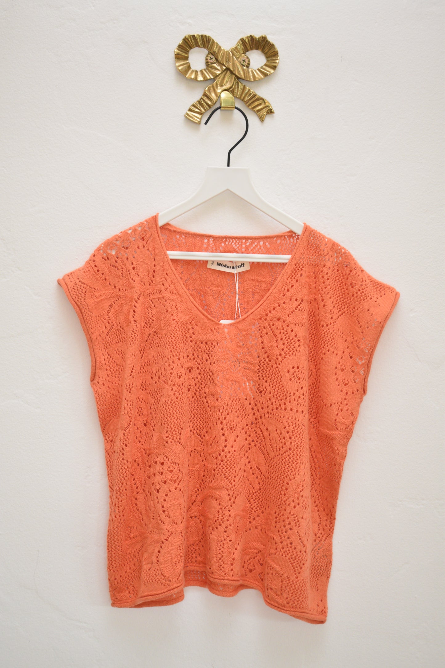 Misha & Puff coral openwork knit cap-sleeve top with V-neck, size 8–9, on hanger against neutral wall.