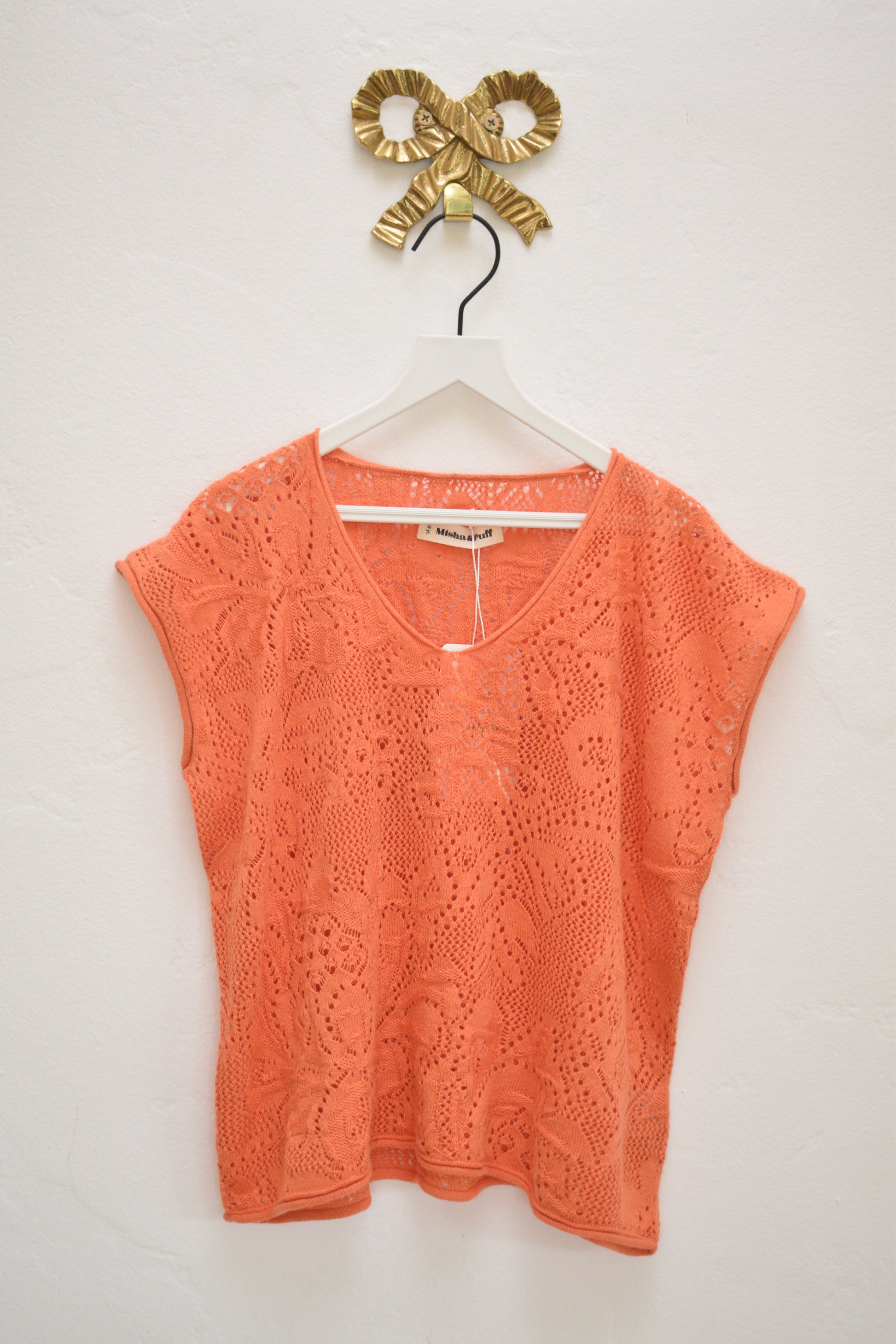 Misha & Puff coral openwork knit cap-sleeve top with V-neck, size 8–9, on hanger against neutral wall.