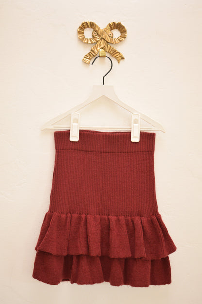 Misha & Puff deep berry knit double-ruffle girls skirt, size 6–7, on hanger against neutral wall.