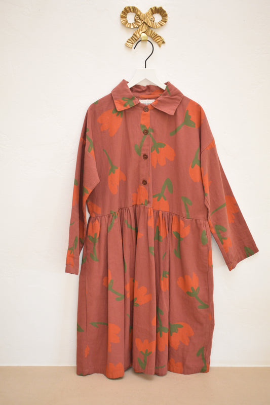 Bobo Choses SS22 ‘I’m a Poet’ clay-red long-sleeve floral shirt dress with gathered waist, size 8–9, on hanger against neutral wall.
