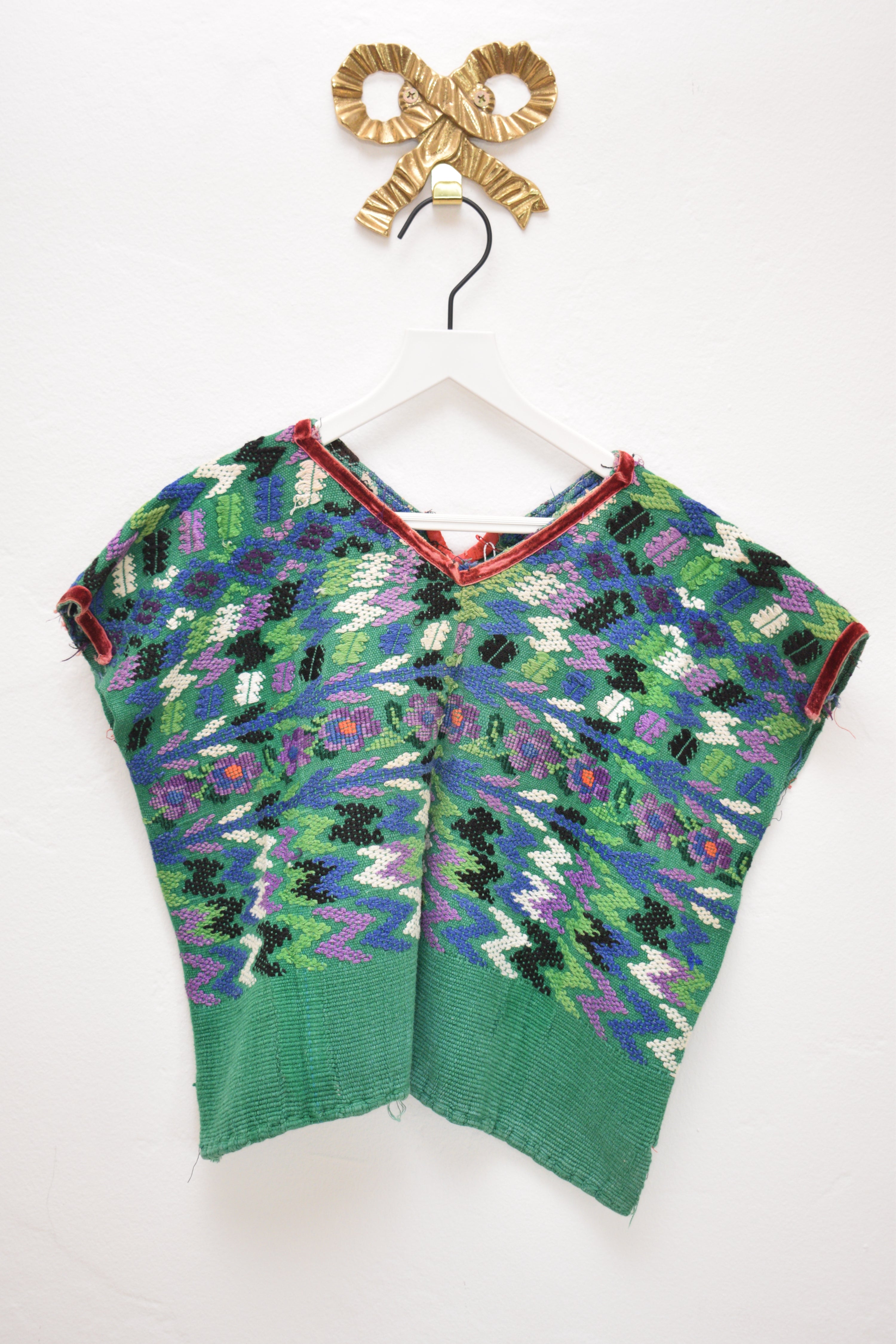 ASA one-of-a-kind woven tapestry top in forest green with multicolor zigzag and floral pattern, size 6–7 years, on a white hanger against a neutral wall.